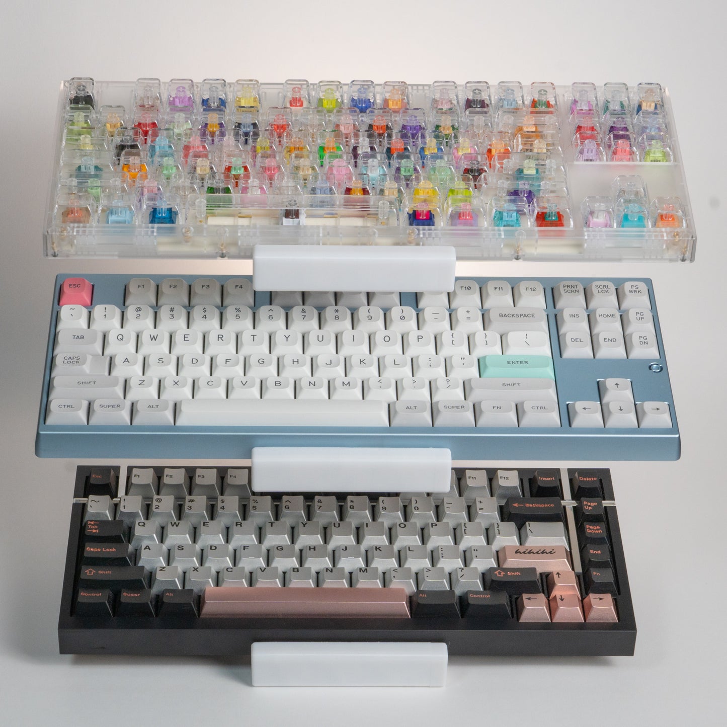 Front view of a white 3-tier keyboard stand holding a switch tester keyboard, a Neo80, and a Box75